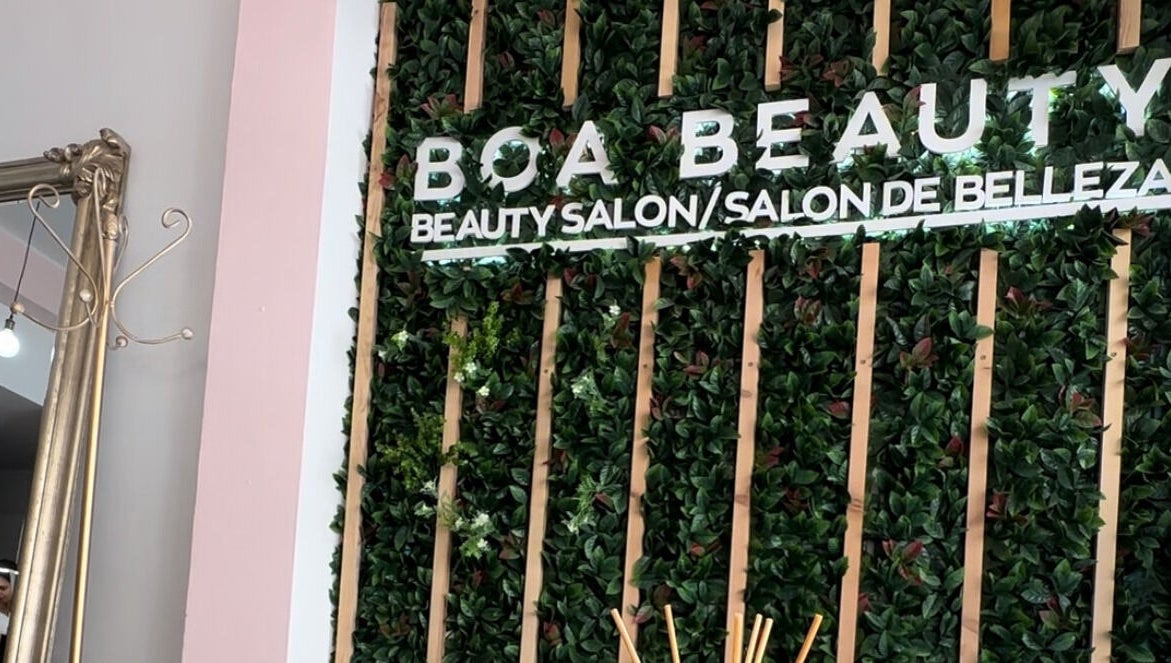 Stylish wall decor in Emma Beth Make-Up, Nerja, Andalucía, ES, with lush greenery and elegant mirror.