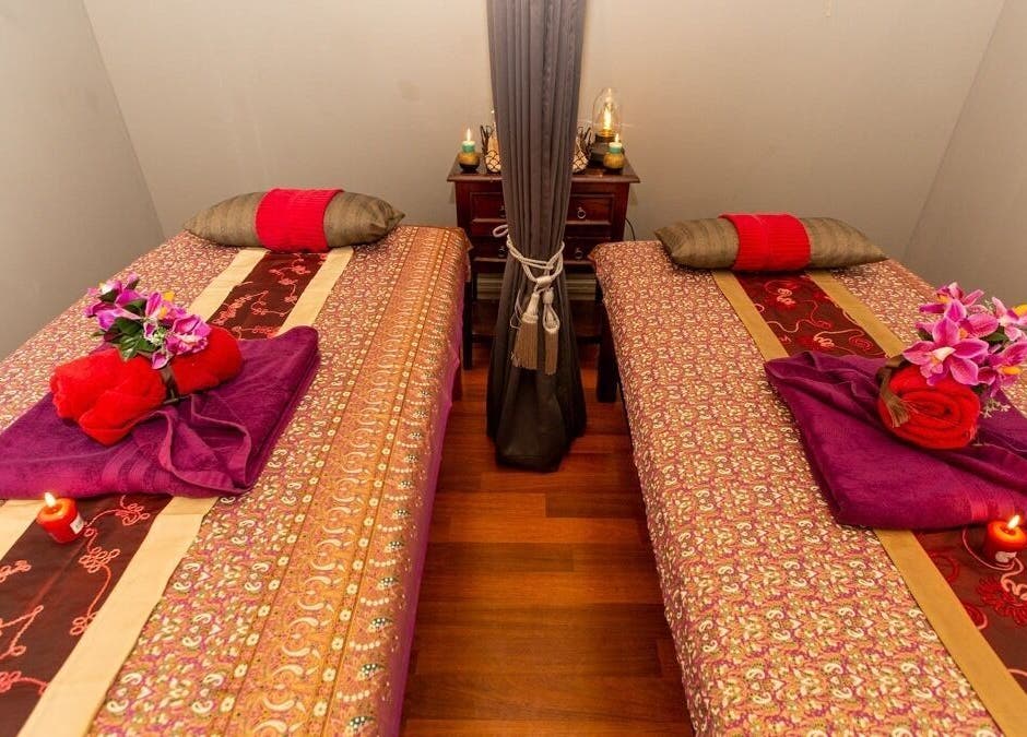 Elegant dual massage beds at Newtown Thai Massage, Enmore, New South Wales, AU, adorned with flowers and candles.