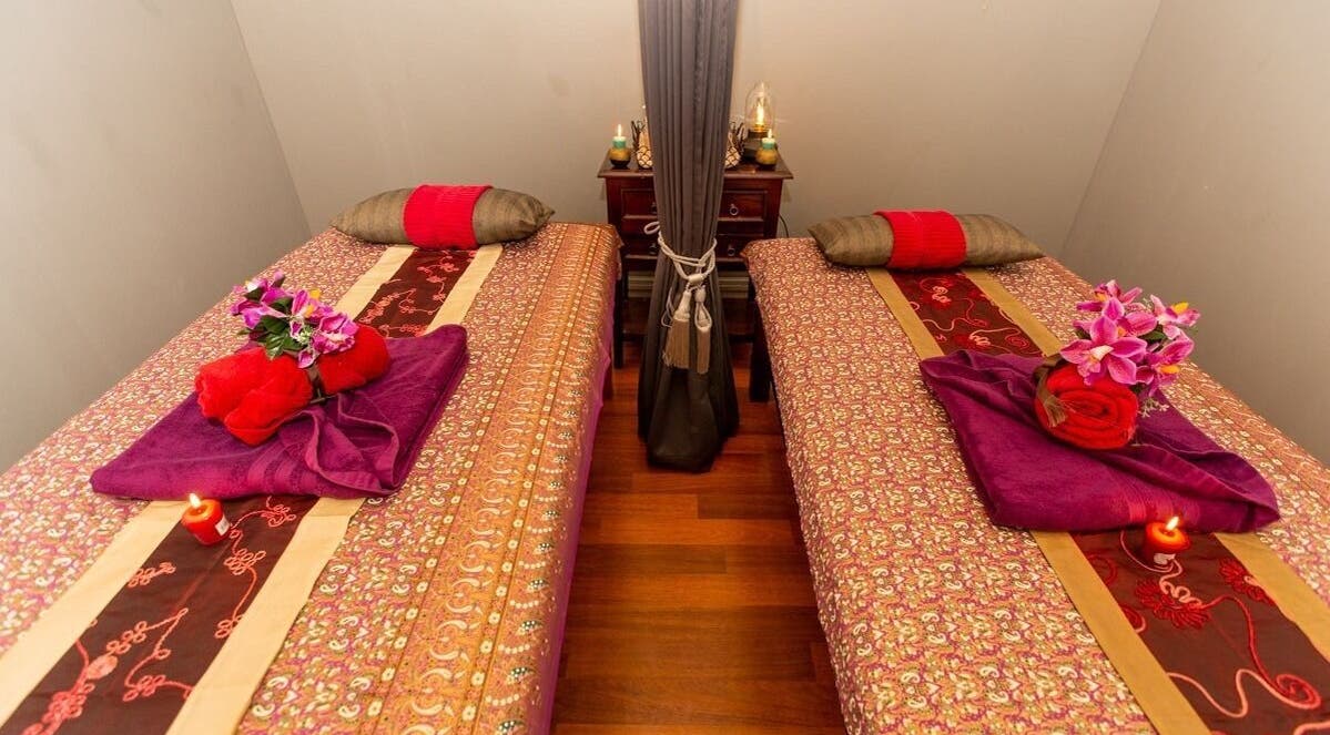 Elegant dual massage beds at Newtown Thai Massage, Enmore, New South Wales, AU, adorned with flowers and candles.