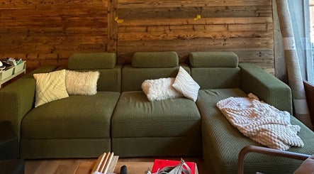 Salon confortable au Alpine Active Lodge, Nendaz, Valais, CH, avec canapé vert et coussins moelleux.
