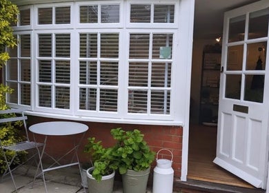 Charming entrance to Stripped Beauty in Basingstoke, England with open door and garden plants.