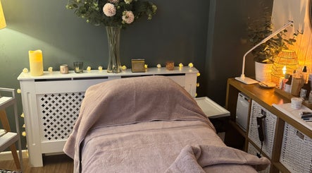 Cozy massage room at Stripped Beauty, Basingstoke, England, GB with soft lighting and floral decor.