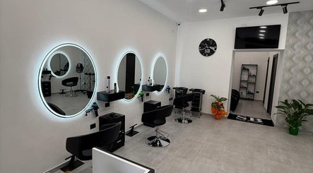 Interno moderno di Sb_HairStudio a Cimitile, Campania, IT con specchi rotondi e sedie nere.
