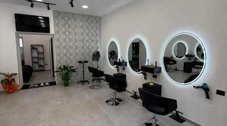Interno elegante di Sb_HairStudio a Cimitile, Campania, IT con specchi rotondi illuminati e postazioni moderne.