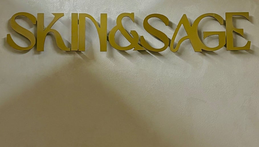 Skin & Sage sign in gold lettering on a textured wall in Cape Town, Western Cape, ZA.