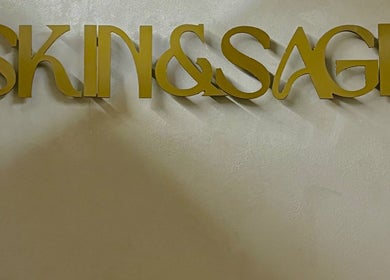Skin & Sage sign in gold lettering on a textured wall in Cape Town, Western Cape, ZA.