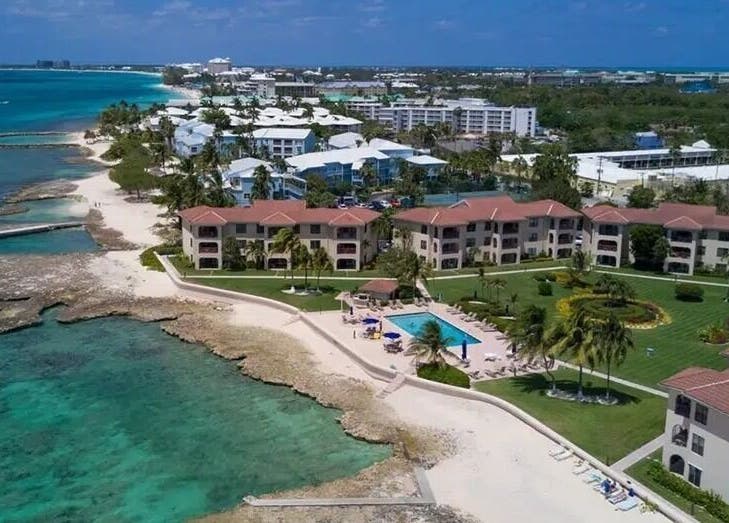 Aerial view of Isla Luxe Lashes near a serene coastline in George Town, George Town, KY, showcasing lush greenery.