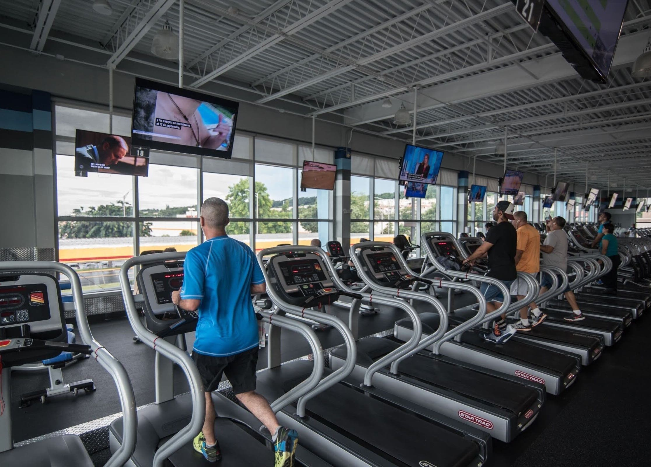 Personas corriendo en cintas en Crunch Fitness Carolina, con vistas panorámicas, Carolina, Carolina, PR.