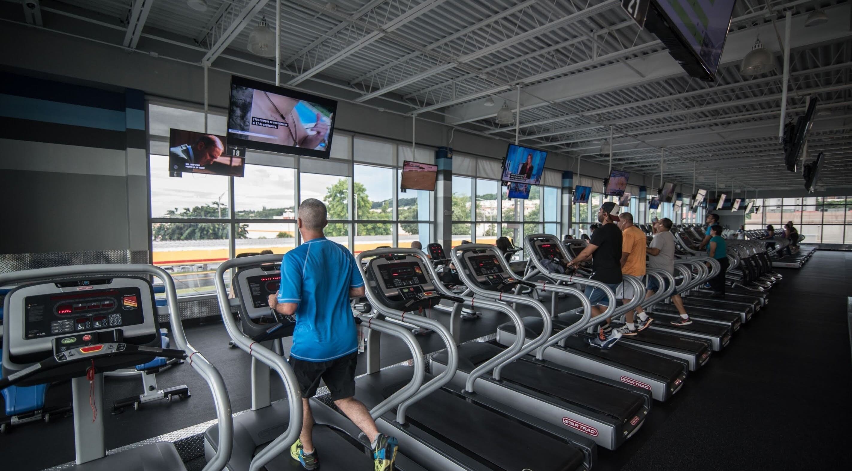 Personas corriendo en cintas en Crunch Fitness Carolina, con vistas panorámicas, Carolina, Carolina, PR.