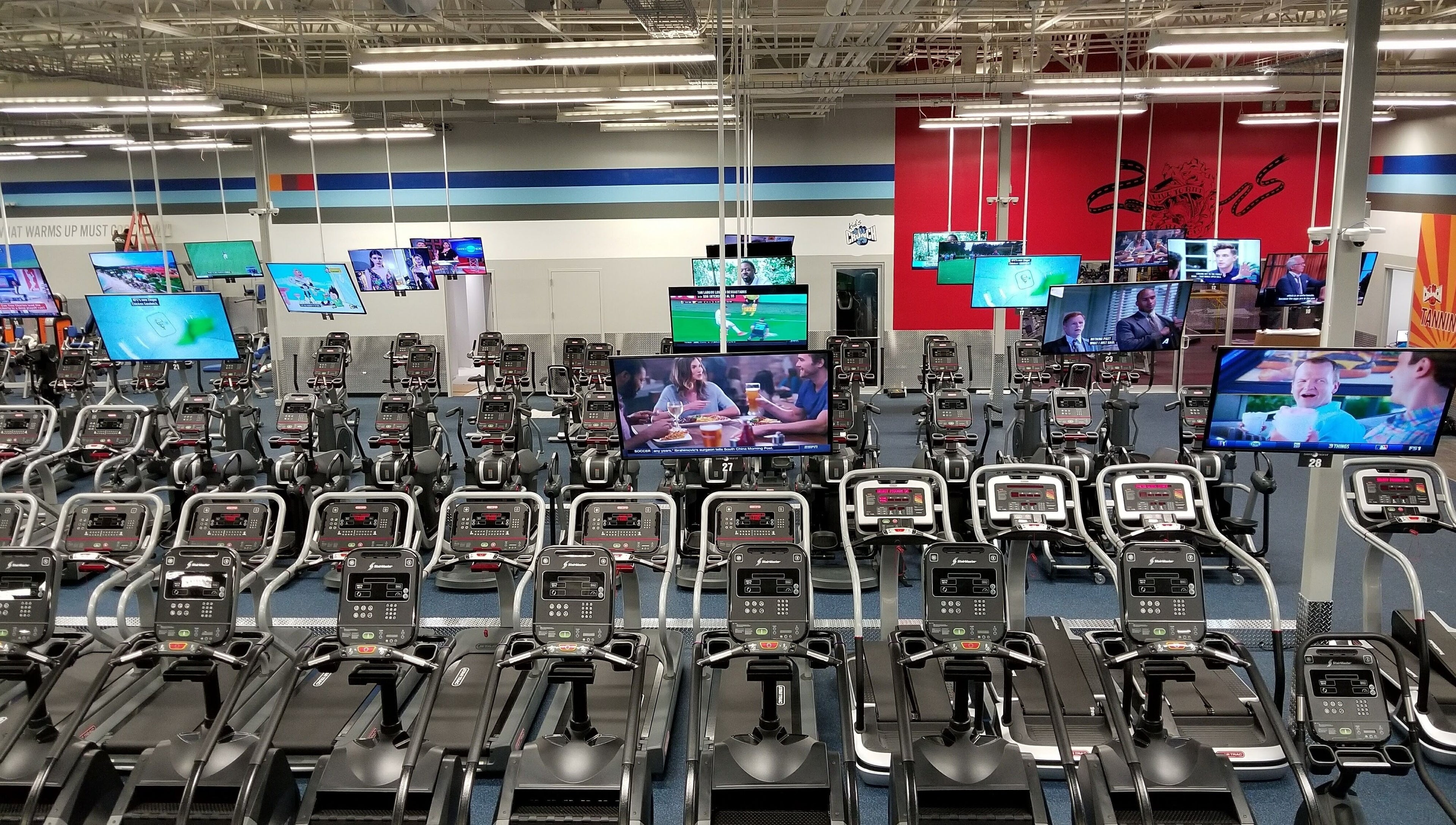 Máquinas de cardio en Crunch Fitness Ponce, Ponce, PR, equipadas con pantallas de TV para entretener durante el ejercicio.