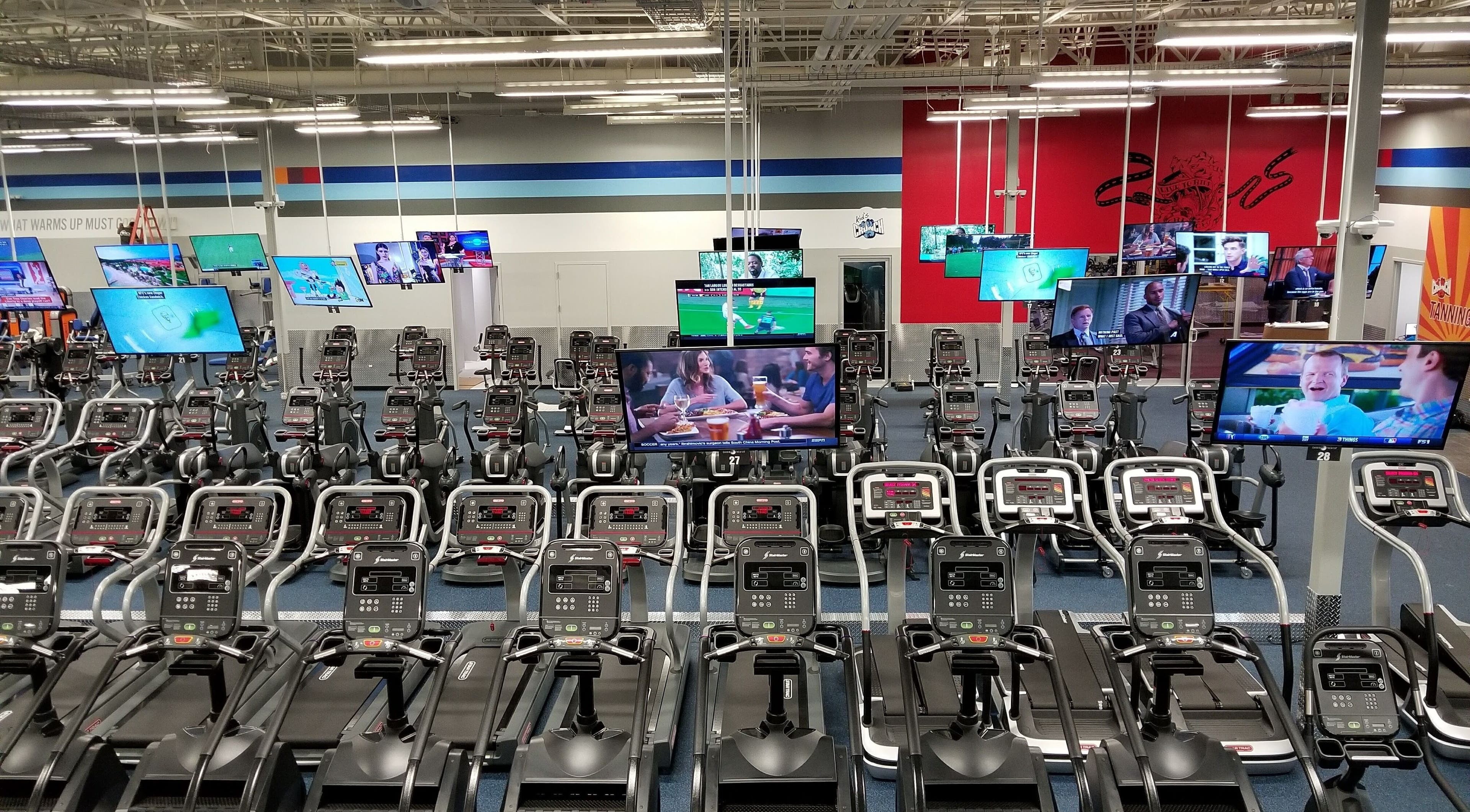 Máquinas de cardio en Crunch Fitness Ponce, Ponce, PR, equipadas con pantallas de TV para entretener durante el ejercicio.