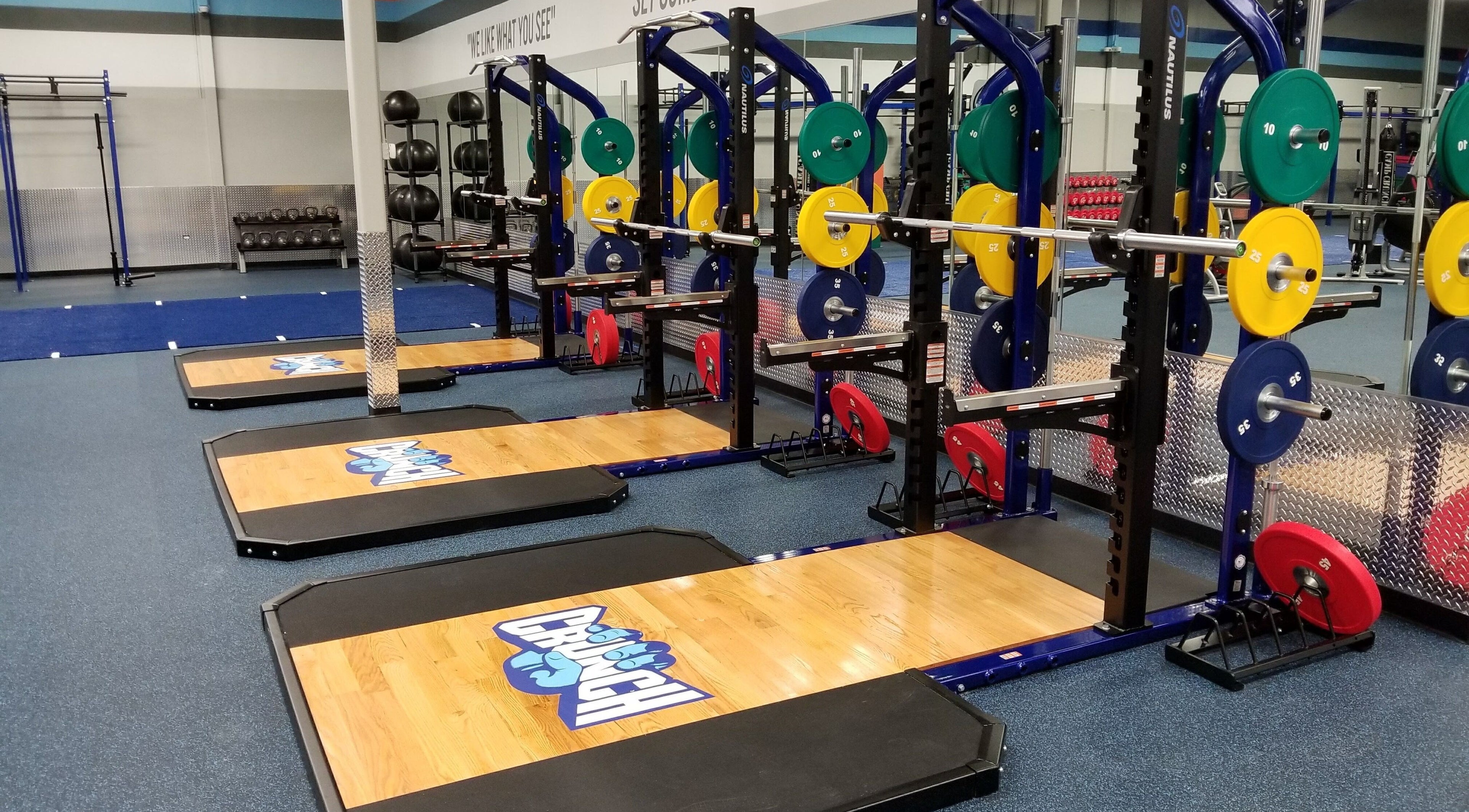 Instalaciones modernas de Crunch Fitness Ponce, Ponce, PR con equipo de pesas colorido y avanzado.