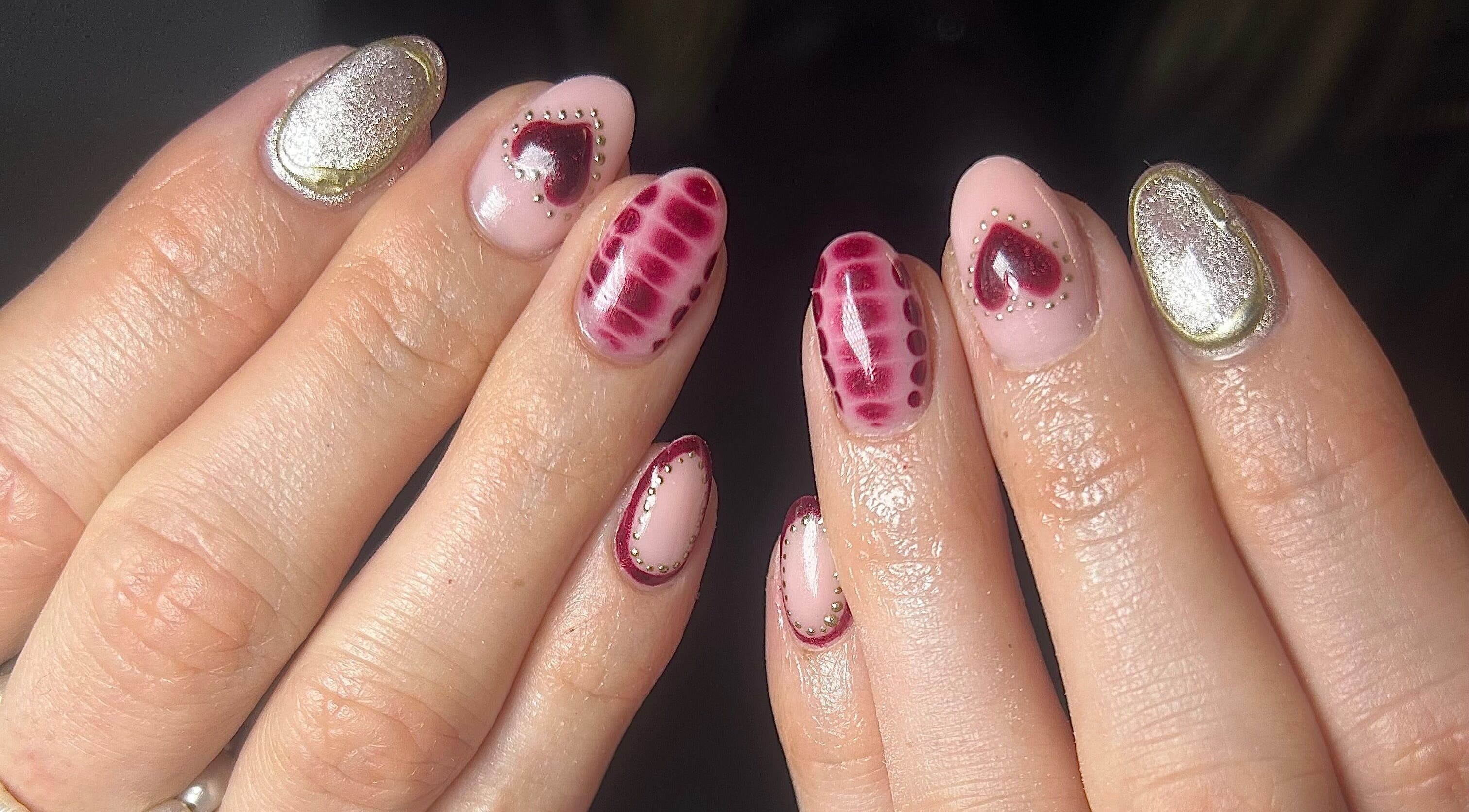 Detailed heart nail art at Nails by Maddy, Truro, England, GB showcasing unique red and gold designs.