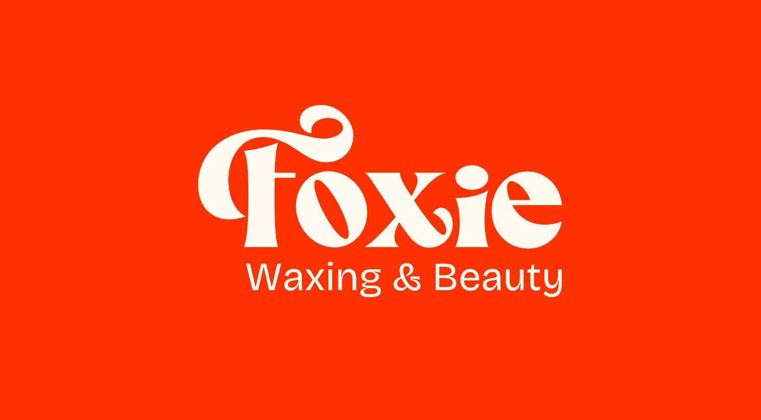 Bold Foxie Waxing & Beauty logo on a vibrant orange background in Auburn, New York, US.