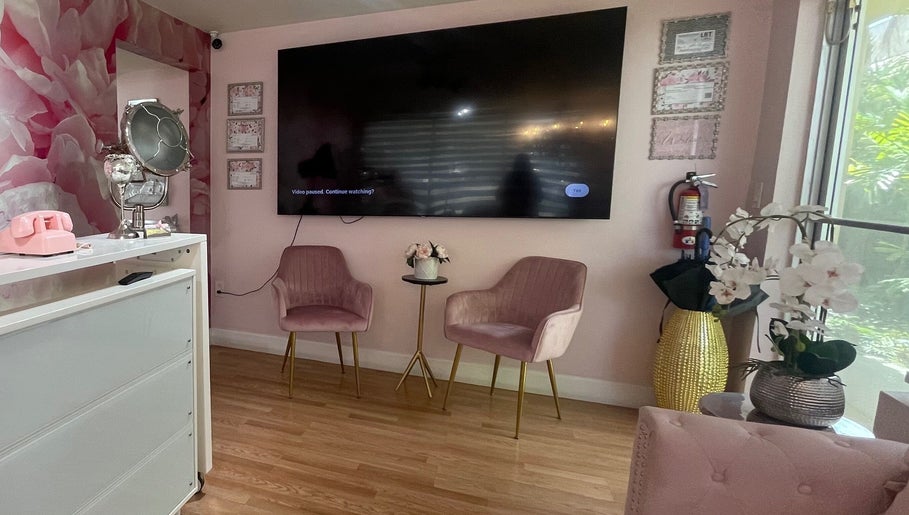 Elegant waiting area in Exlat Skin Care Suites, Hialeah, Florida, US with pink chairs and floral decor.