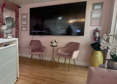 Elegant waiting area in Exlat Skin Care Suites, Hialeah, Florida, US with pink chairs and floral decor.