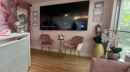 Elegant waiting area in Exlat Skin Care Suites, Hialeah, Florida, US with pink chairs and floral decor.