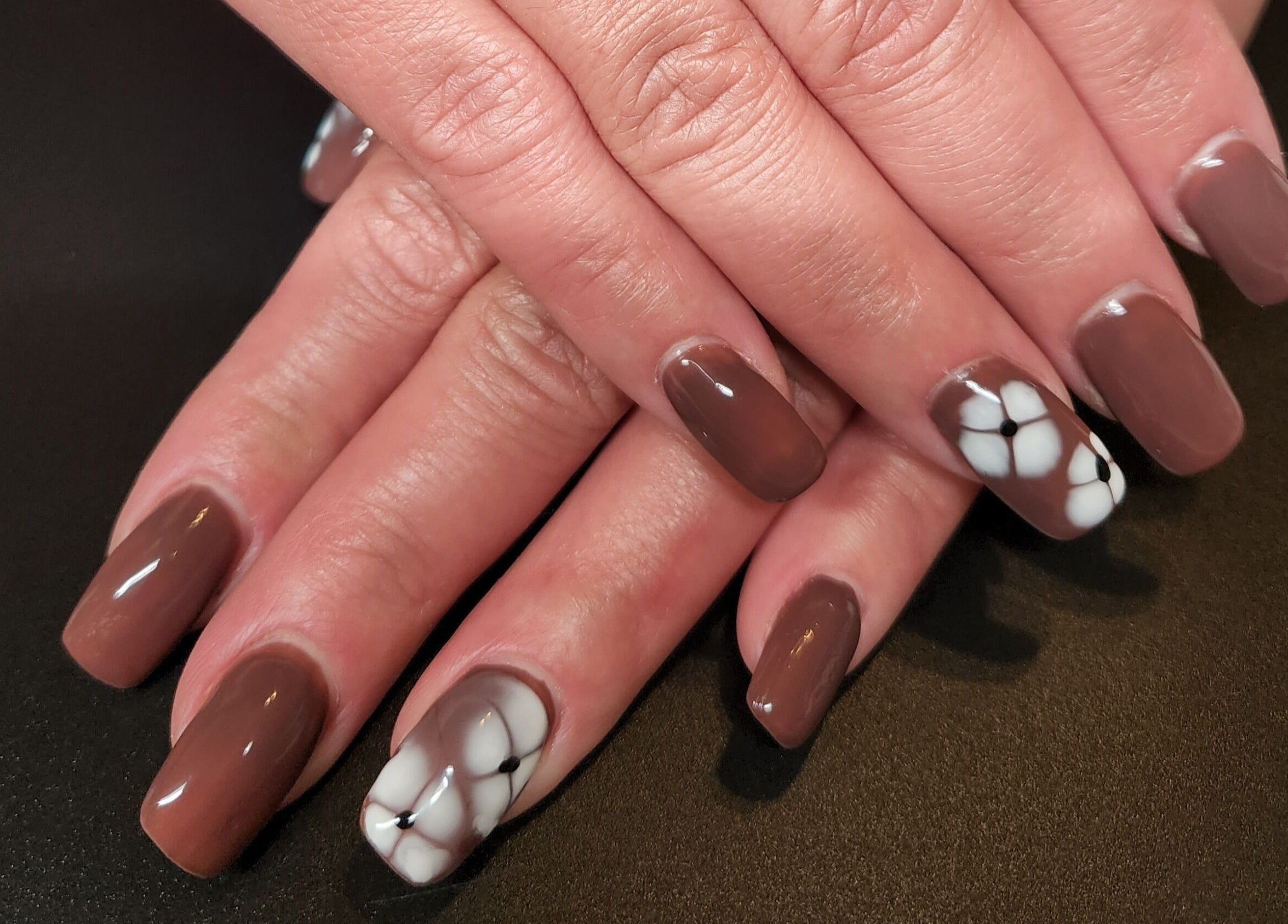 Stylish brown nails with flower design at Netty's Nail Studio, Pocatello, Idaho, US.