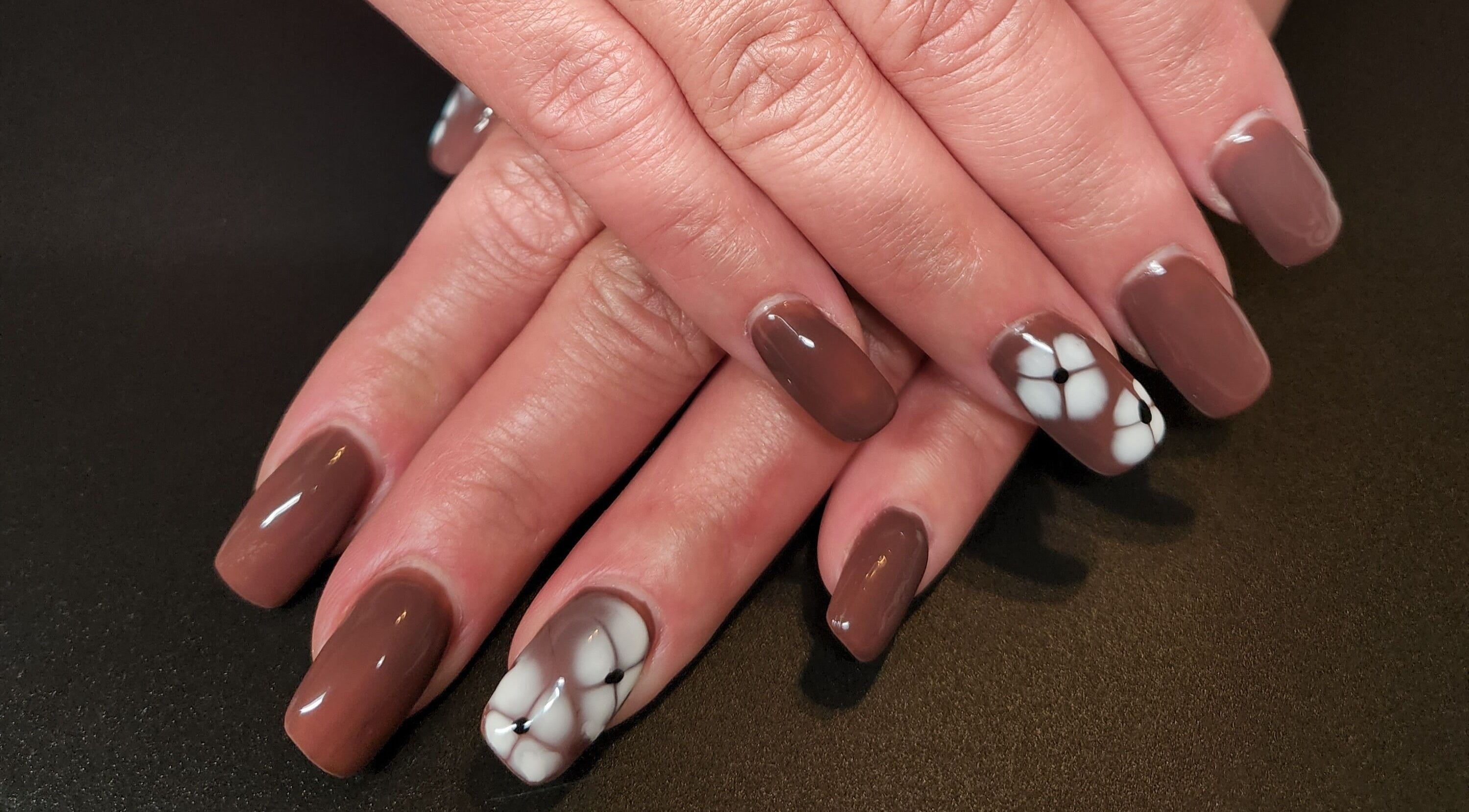 Stylish brown nails with flower design at Netty's Nail Studio, Pocatello, Idaho, US.