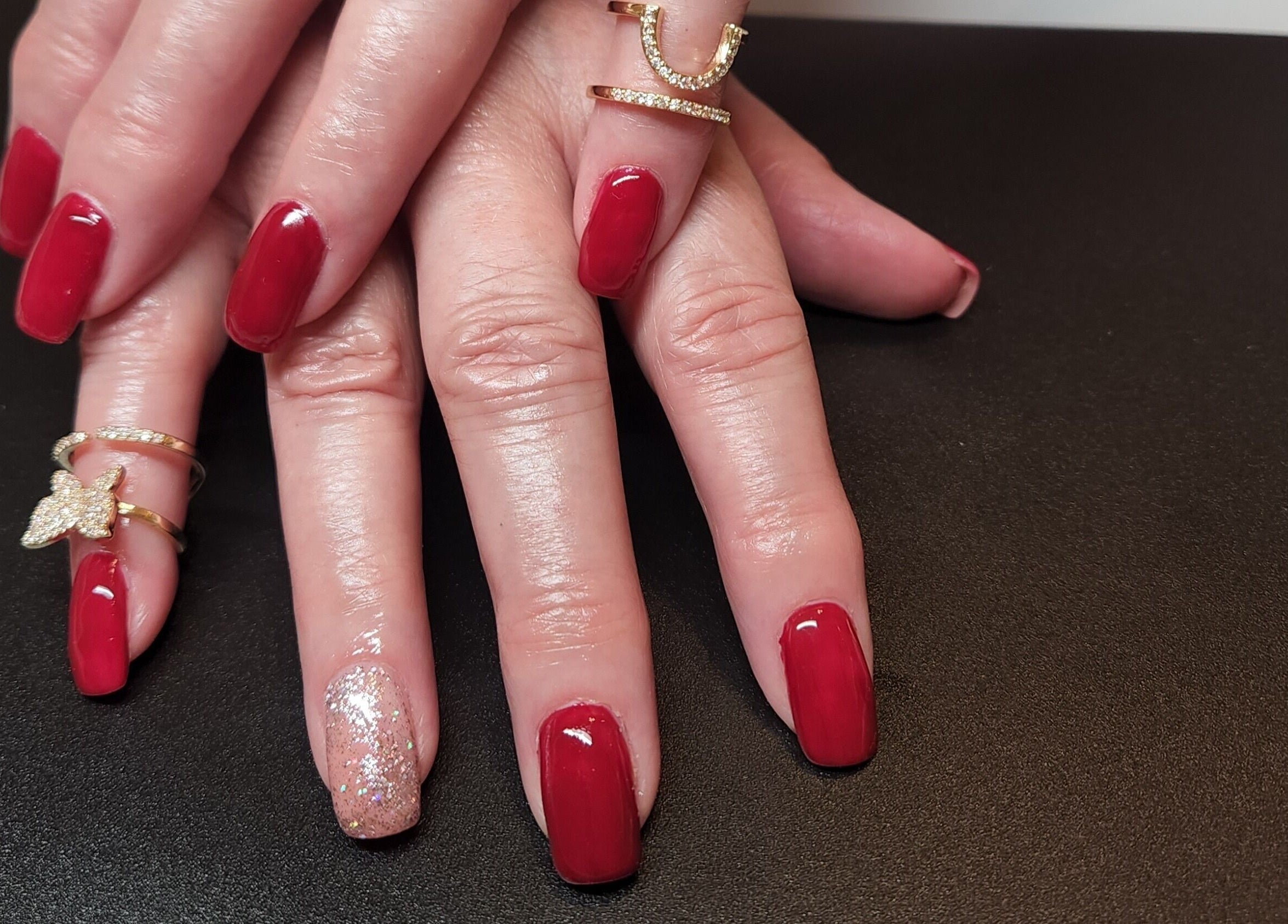 Elegant red manicure with glitter accent at Netty's Nail Studio, Pocatello, Idaho, US.