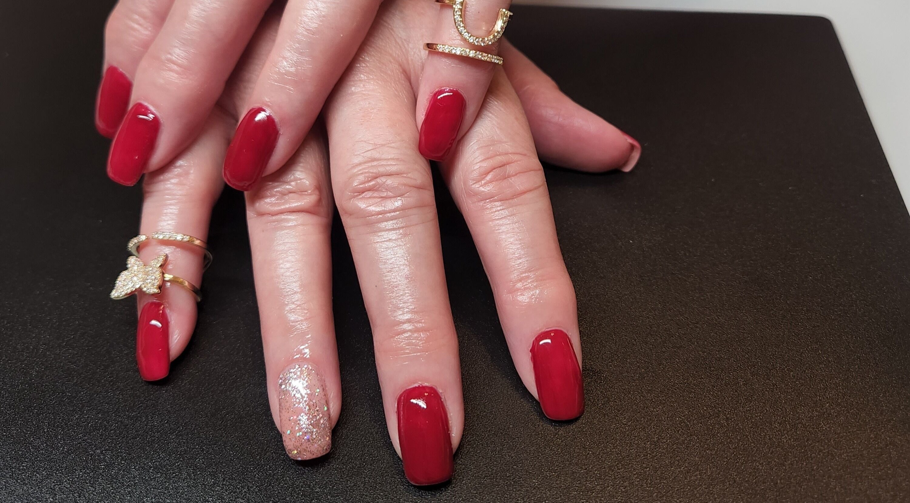Elegant red manicure with glitter accent at Netty's Nail Studio, Pocatello, Idaho, US.