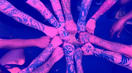 Braços tatuados unidos em círculo na Wall Arcanjo academy, São Paulo, São Paulo, BR.