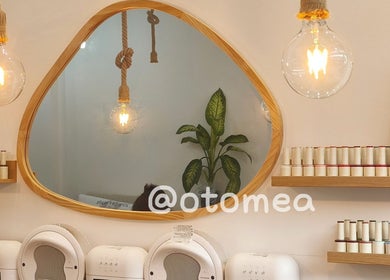 Otomea 伦敦店内景观，木质圆镜与柔和灯光，彰显自然美学。