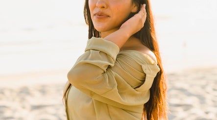Woman enjoys serene beach near Sixth Sense Salon, Orange, California, US, highlighting natural beauty.
