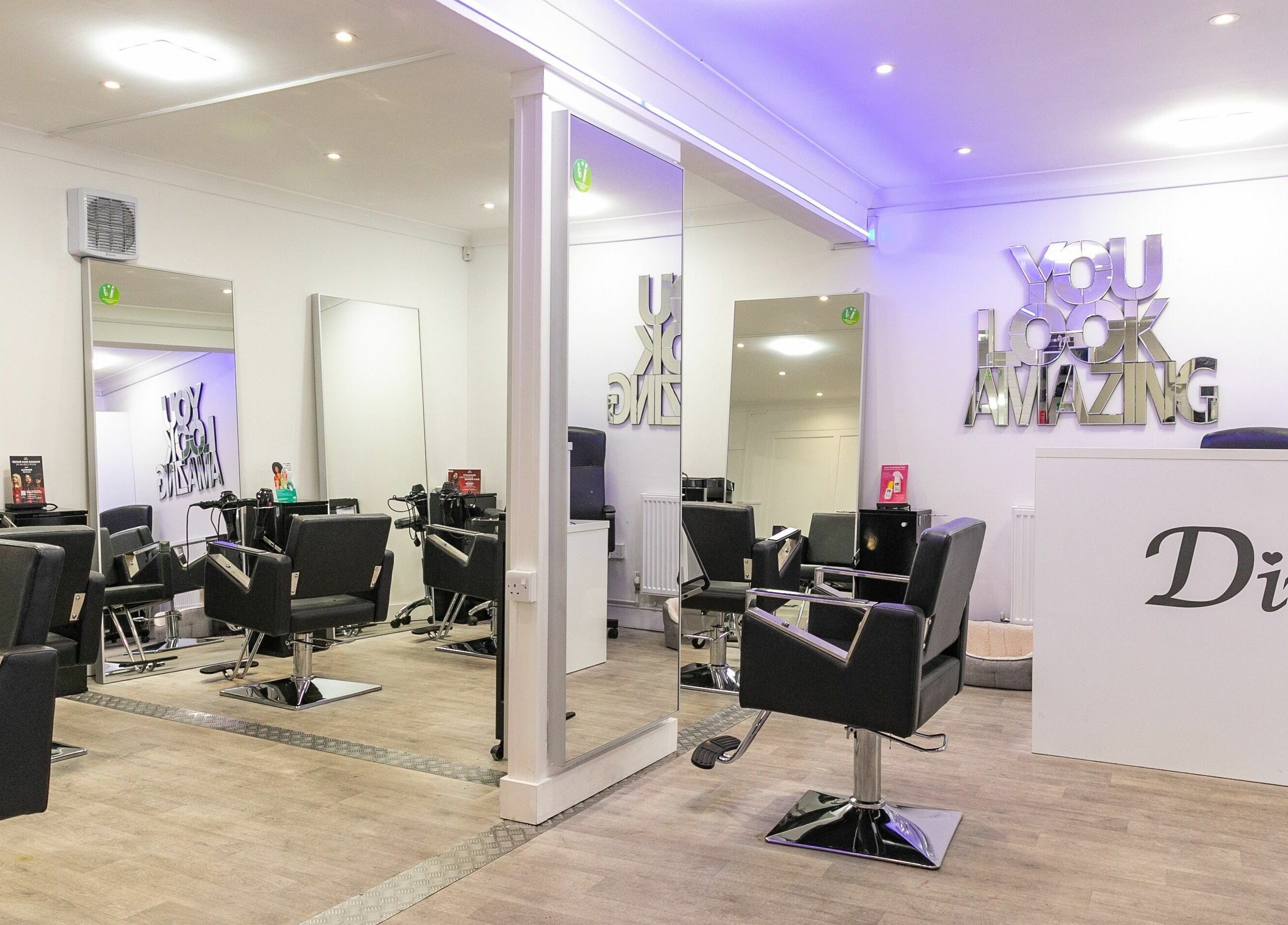 Chic salon interior at Divas Hair, located in Cheshunt, England, GB, with stylish chairs and modern decor.