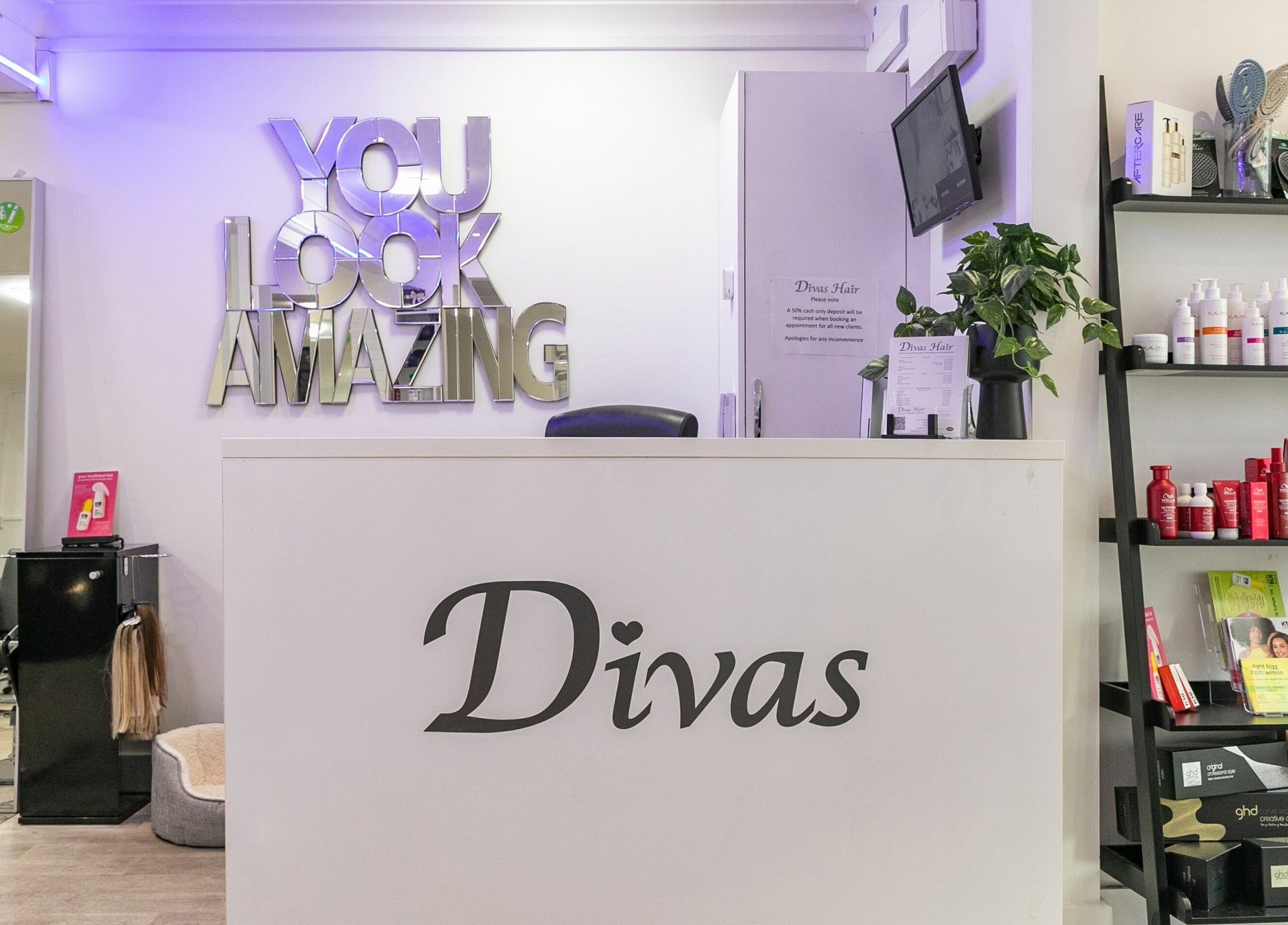 Reception area of Divas Hair in Cheshunt, England, GB featuring stylish decor and product displays.