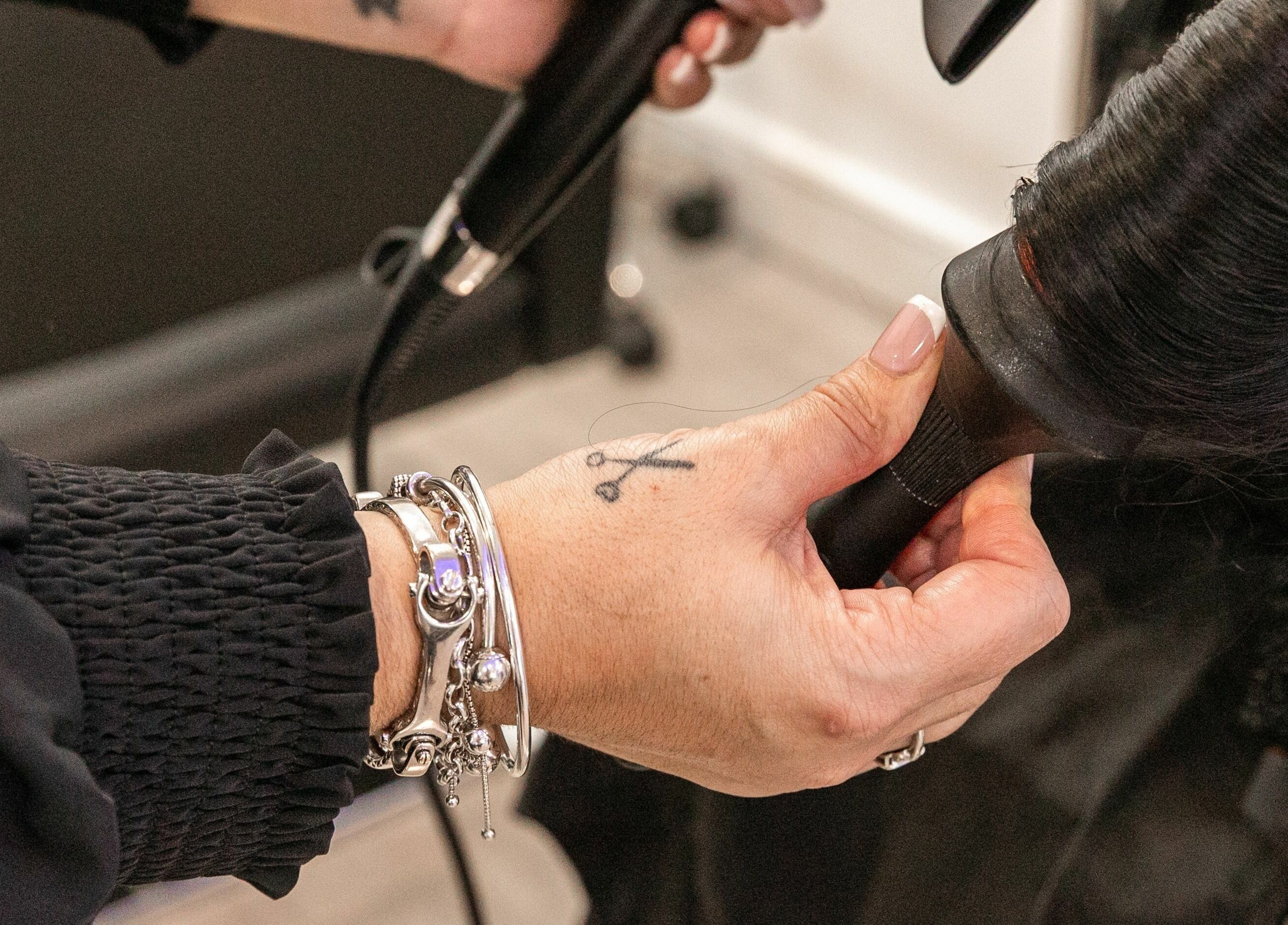 Hair stylist at Divas Hair in Cheshunt, England, GB expertly blow-drying a client's hair.