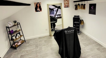 Inside BeyondLengthEssex salon, Dunmow, England, GB. Elegant mirror and professional styling chairs featured.