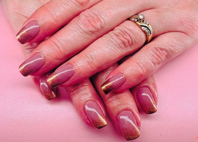 Stylish glossy nails with gold accents at Mystique Nails, Alpena, Michigan, US.