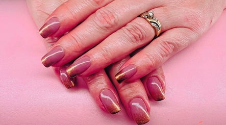 Stylish glossy nails with gold accents at Mystique Nails, Alpena, Michigan, US.