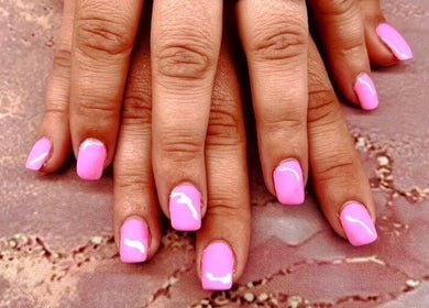Glossy pink manicure at Mystique Nails, Alpena, Michigan, US showcasing elegant nail art.