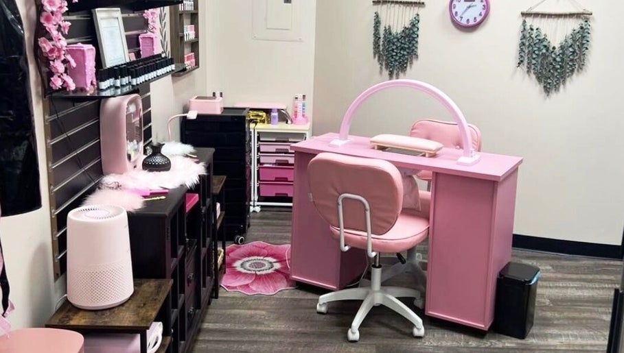 Chic nail station at Mystique Nails, Alpena, Michigan, US featuring plush pink seating and elegant decor.