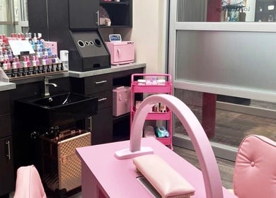 Stylish pink nail station at Mystique Nails in Alpena, Michigan, US, showing manicure setup and supplies.