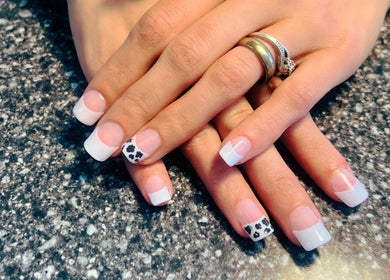 Stylish French manicure with leopard print at Mystique Nails, Alpena, Michigan, US.
