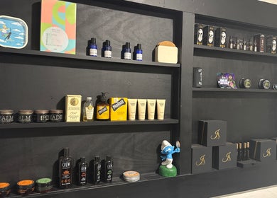 Display of grooming products at The Vigilante Barber in Erakala, Queensland, AU. Elegant black shelves filled with various items.