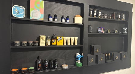 Display of grooming products at The Vigilante Barber in Erakala, Queensland, AU. Elegant black shelves filled with various items.