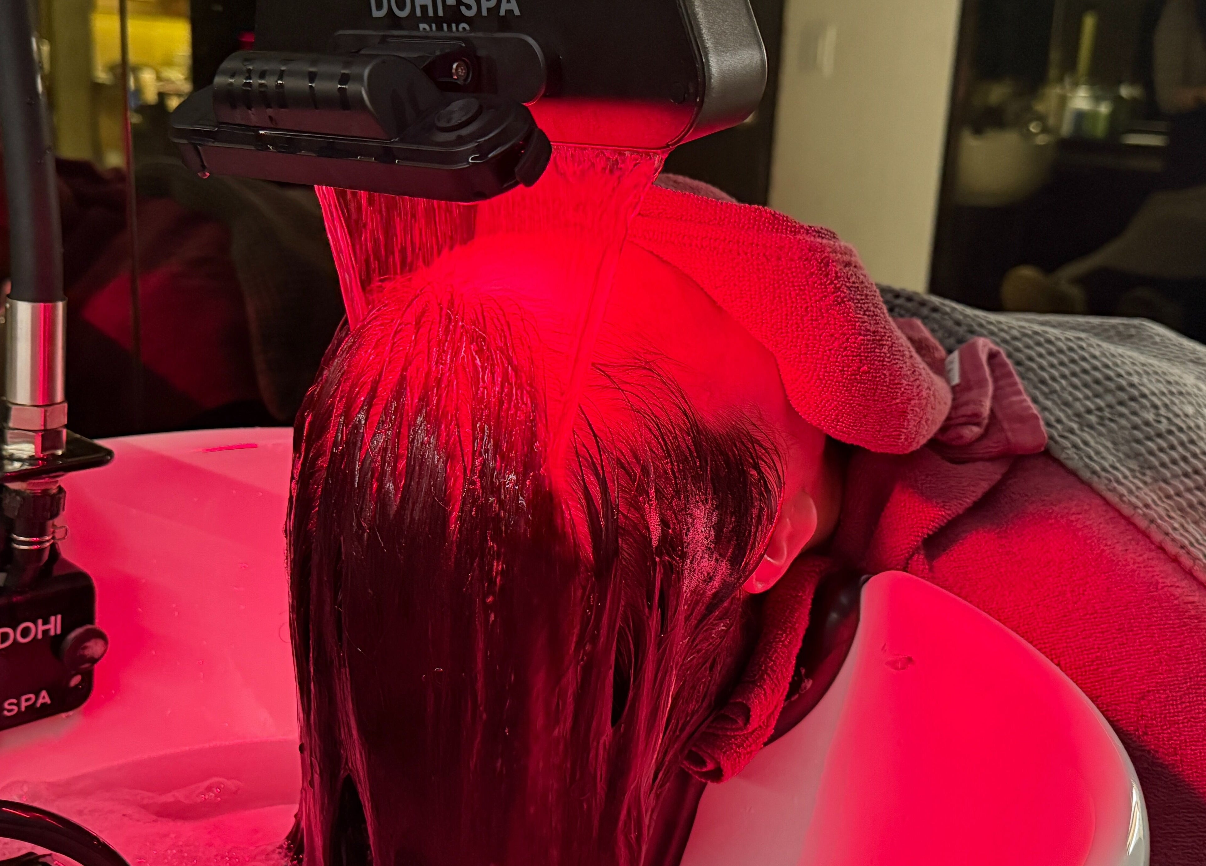 Client enjoying a red light therapy hair spa at 이철헤어커커 명동2호점 LeeChul HairKerker Myeongdong 2nd Branch, Seoul, KR.