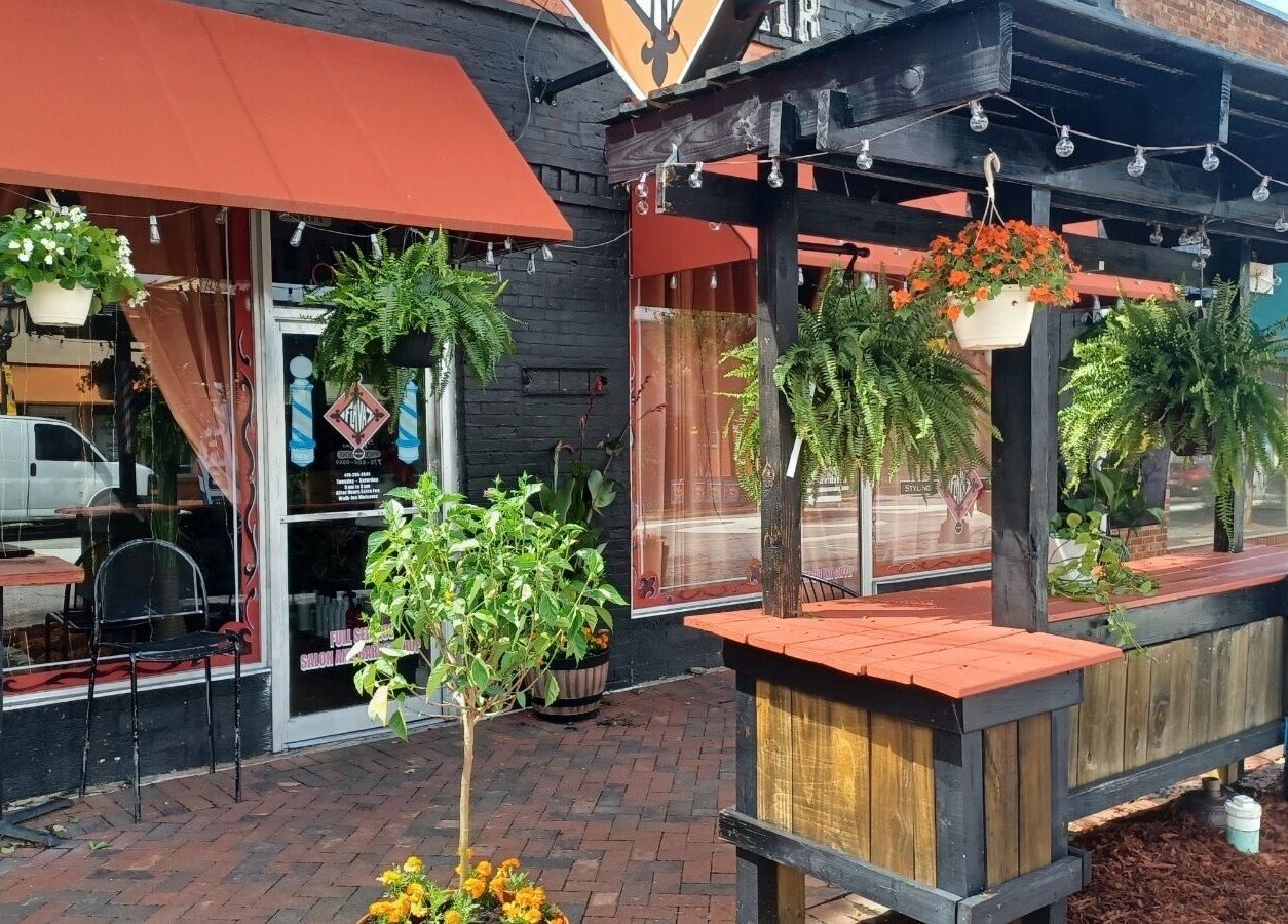 Cozy outdoor setting at Kay's Kraft, a beauty venue in Lithonia, Georgia, US, adorned with hanging plants.