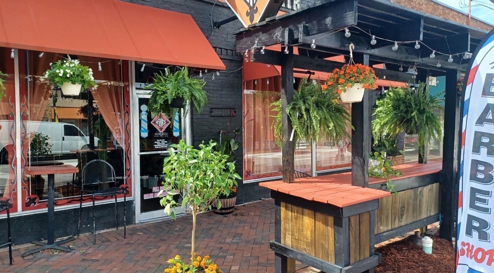 Cozy outdoor setting at Kay's Kraft, a beauty venue in Lithonia, Georgia, US, adorned with hanging plants.
