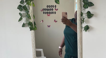 Mirror with vines and butterflies at Nika’s Styles & Smiles, Castries, LC, reflecting a serene setting.