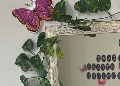 Decorative butterfly and greenery near mirror at Nika’s Styles & Smiles, Castries, Castries, LC.