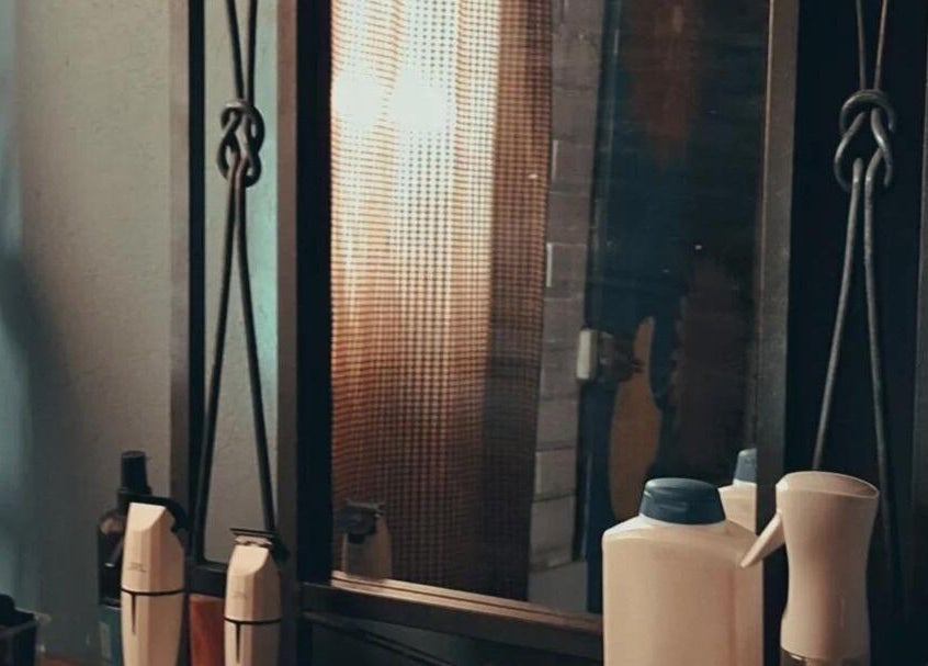 Espejo en Barbería Punto de Encuentro, Quilicura, Región Metropolitana, CL, mostrando productos de peluquería.