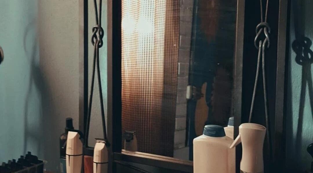 Espejo en Barbería Punto de Encuentro, Quilicura, Región Metropolitana, CL, mostrando productos de peluquería.