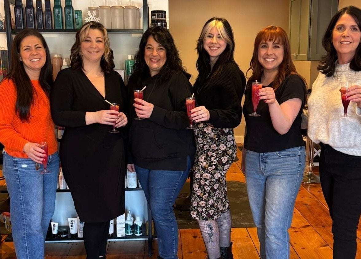 Team of stylists celebrating at Freya Beauty Salon in Derry, New Hampshire, US with colorful drinks.