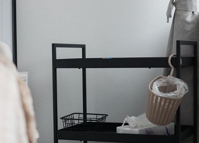 Minimalist interiér NŪSYE STUDIO, Žilinský Kraj, SK s moderním pojízdným stolkem a dekorativními prvky.