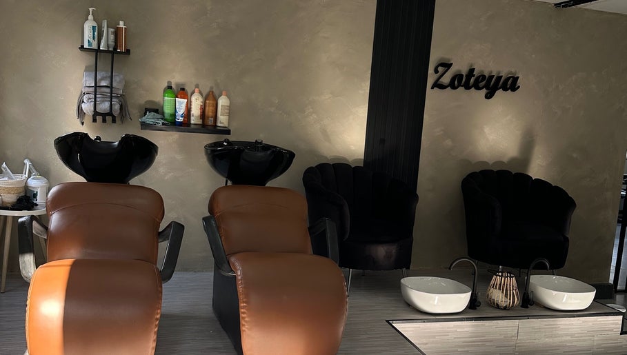 Luxurious wash area at Zoteya Beauty Salon, Sandton, Gauteng, ZA. Cozy chairs and premium hair products displayed.